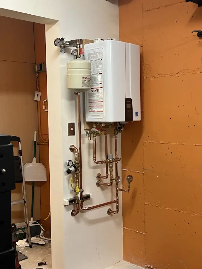 Plumbing technician inspecting water heater connections in Sandy Springs
